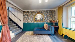 een woonkamer met een blauwe stoel en een trap bij Newly Renovated Cottage - Forest of Dean - Pet Friendly with Sauna in Coleford