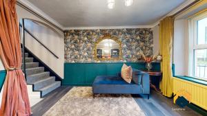 a living room with a blue chair and a staircase at Newly Renovated Cottage - Forest of Dean - Pet Friendly with Sauna in Coleford