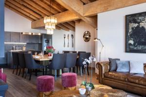 a living room with a couch and a table and chairs at Chalet Carte Blanche Golden Jubilée in Val Thorens