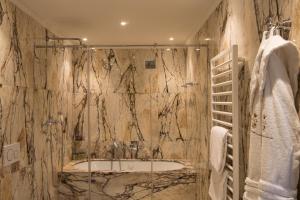 a bathroom with a shower and a bath tub at Hotel Nani Mocenigo Palace in Venice +37 photos