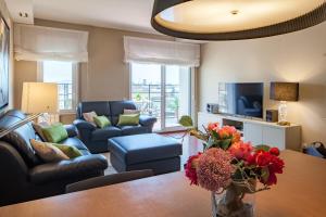 a living room with a vase of flowers on a table at Habitat Apartments Tessa in Barcelona