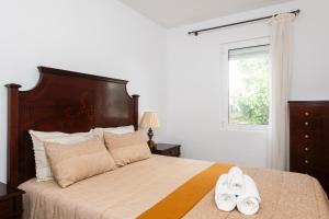 a bedroom with a bed with two white towels on it at Olivais Vintage by Homing in Lisbon