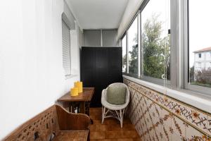 a balcony with a table and a chair and windows at Olivais Vintage by Homing in Lisbon