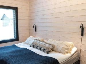 een bed in een kamer met houten wanden bij Holiday Home Saanan helmi by Interhome in Kilpisjärvi