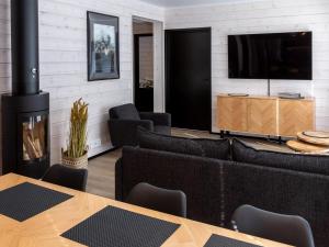 een woonkamer met een open haard en een televisie bij Holiday Home Saanan helmi by Interhome in Kilpisjärvi