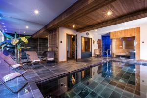 an indoor swimming pool with chairs and a house at Chalet Carte Blanche Golden Jubilée in Val Thorens