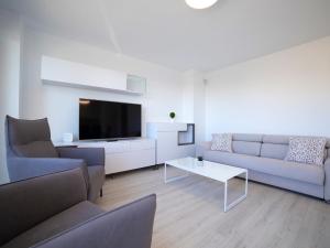 ein Wohnzimmer mit einem Sofa und einem TV in der Unterkunft Apartment Isea Calpe-6 by Interhome in Calpe