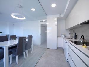 eine weiße Küche mit einem Esstisch und Stühlen in der Unterkunft Apartment Isea Calpe-6 by Interhome in Calpe