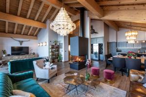 a living room with a couch and a chandelier at Chalet Carte Blanche Golden Jubilée in Val Thorens
