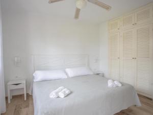 a bedroom with a white bed with two towels on it at Apartment Son Bou Gardens Apt 3 dorm by Interhome in Son Bou