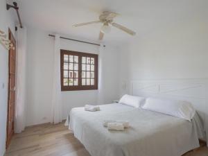 a white bedroom with a bed with two towels on it at Apartment Son Bou Gardens Apt 3 dorm by Interhome in Son Bou