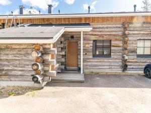 una cabaña de madera con una puerta y un coche aparcado fuera en Holiday Home Nilikuru f15 by Interhome, en Saariselkä