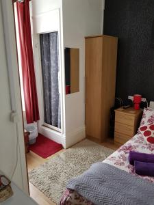 a bedroom with a mirror and a bed and a dresser at Sunnyside Hotel in Great Yarmouth