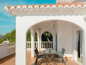 a white house with a table and chairs on a balcony at Holiday Home Son Bou Sunset 49 by Interhome in Alaior
