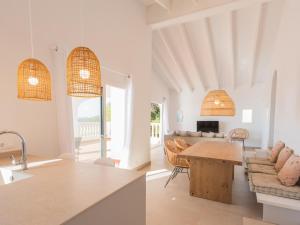 eine Küche und ein Wohnzimmer mit einem Tisch und Stühlen in der Unterkunft Holiday Home Son Bou Sunset 49 by Interhome in Alaior
