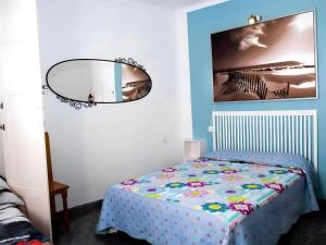 科尼爾－德拉弗龍特拉的住宿－Dúplex Goya céntrico familias y parejas，一间小卧室,配有一张床和镜子