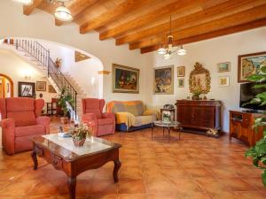 uma sala de estar com cadeiras vermelhas e uma mesa em Villa Can Mestre by Interhome em Selva