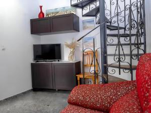 科尼爾－德拉弗龍特拉的住宿－Dúplex Goya céntrico familias y parejas，客厅配有红色沙发和电视