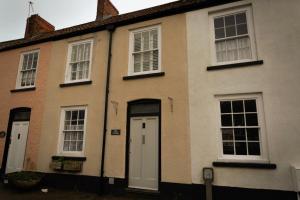 una casa con puertas y ventanas blancas en Stunning period cottage en Wrington