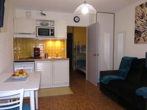 uma cozinha e uma sala de estar com uma mesa em Apartment La Pomme de Pin by Interhome em La Baule-les-Pins