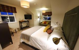 a bedroom with a large white bed and a television at Sixty Six in Glenoe