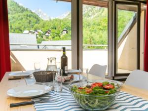 einen Tisch mit einer Schüssel Gemüse auf einem Tisch mit einem Fenster in der Unterkunft Apartment Les Hameaux de la Perrière-2 by Interhome in Saint-Colomban-des-Villards
