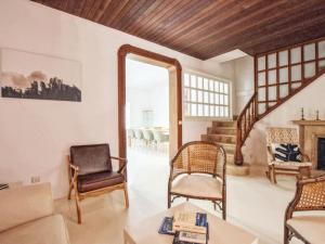 ein Wohnzimmer mit einem Sofa, Stühlen und einem Spiegel in der Unterkunft Holiday Home Padrina by Interhome in Artá