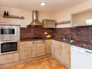 a kitchen with wooden cabinets and stainless steel appliances at Apartment Codolar by Interhome in Tossa de Mar