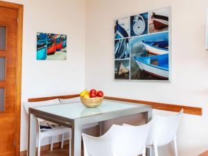 uma mesa e cadeiras com uma tigela de fruta em Apartment Codolar by Interhome em Tossa de Mar