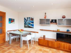 a dining room with a table and a tv at Apartment Codolar by Interhome in Tossa de Mar