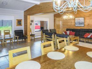 ein Esszimmer mit Tischen, Stühlen und einem Sofa in der Unterkunft Holiday Home Vuolkuma a by Interhome in Saariselkä