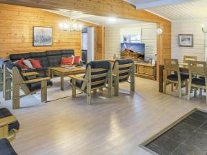ein Wohnzimmer mit einem Sofa, einem Tisch und Stühlen in der Unterkunft Holiday Home Vuolkuma a by Interhome in Saariselkä