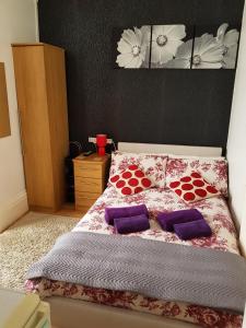 a bedroom with a bed with purple pillows on it at Sunnyside Hotel in Great Yarmouth