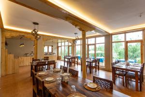 a dining room with tables and chairs and windows at Sand Dunes Retreat in Leh