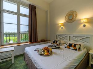 een hotelkamer met een bed en een dienblad met fruit erop bij Apartment Le Château de Kergonano-14 by Interhome in Baden