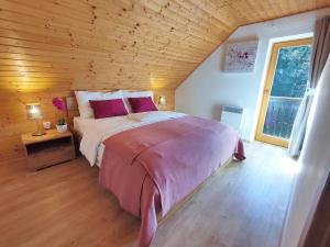 um quarto com uma cama grande e um tecto em madeira em Sweet Stay Forest House em Vrhnika