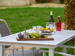 - une table blanche avec une assiette de nourriture et des bouteilles de vin dans l'établissement Apartment Le Château de Kergonano-9 by Interhome, à Baden