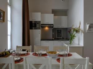 une cuisine avec une table et des chaises blanches ainsi qu'une salle à manger dans l'établissement Apartment Le Château de Kergonano-9 by Interhome, à Baden