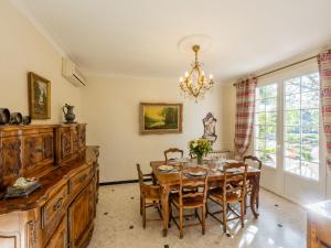 a dining room with a table and chairs and a chandelier at Holiday Home Le Clos Saint Emilie - Tennis & piscine by Interhome in Béziers +29 photos