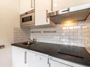 a kitchen with a sink and a microwave at Studio Home Club - Lavachet-11 by Interhome in Tignes