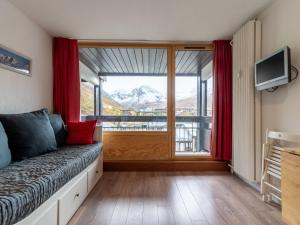 a room with a couch and a large window at Studio Home Club - Lavachet-11 by Interhome in Tignes