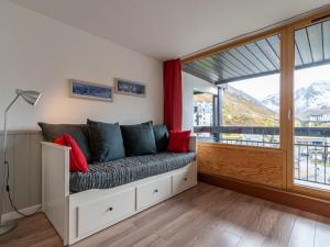 a living room with a couch and a large window at Studio Home Club - Lavachet-11 by Interhome in Tignes