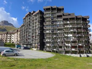 a large building with cars parked in a parking lot at Studio Home Club - Lavachet-11 by Interhome in Tignes