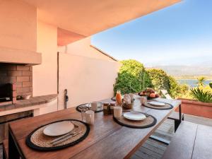 una mesa de madera con platos en el balcón en Holiday Home Verde by Interhome, en Porto Vecchio