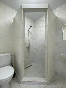 uma casa de banho branca com um chuveiro e um WC. em Naciku SPA Hotel em Bukovel