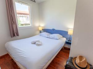 a bedroom with a bed with a hat on it at Apartment Les Hameaux de La Chalosse-2 by Interhome in Cassen