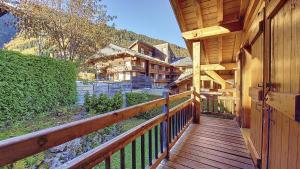Una pasarela de madera que conduce a un balcón de una casa en Chalet MB, en Saint-Jean-dʼAulps