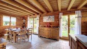 a dining room with a table and some windows at Chalet MB in Saint-Jean-d'Aulps