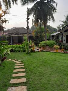 um jardim com um caminho de pedra em frente a uma casa em Atharva Holiday Homes em Anjuna