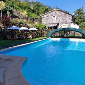 ein blauer Pool vor einem Haus in der Unterkunft Gîte le Murier- le moulin de Lagharde in Rochessauve